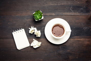 Obraz na płótnie Canvas white ceramic cup with black coffee on brown wooden table,