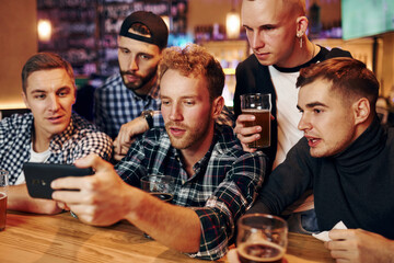 Group of people together indoors in the pub have fun at weekend time