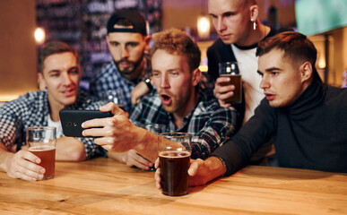 Group of people together indoors in the pub have fun at weekend time