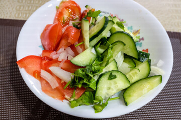 Cucumber and tomato salad on a plate.