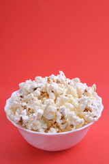 Popcorn in bowl on a red background. Close up. Top view