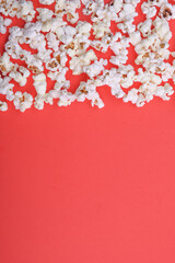 Popcorn on red background top view close up