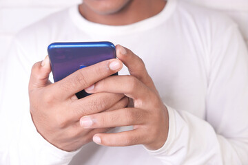 young man in white casual dress using smart phone.