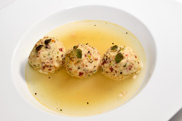 Tyrolean canederli, Bread dumplings in broth on a white plate