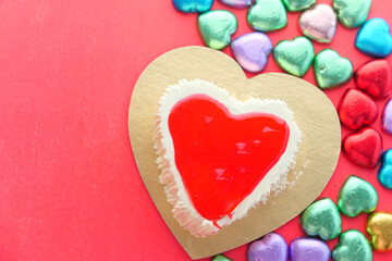 Top view of heart shape cake and candy on red background 