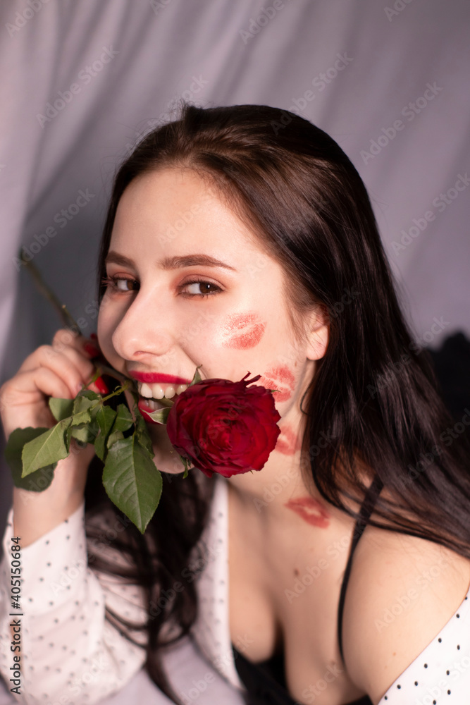 Wall mural sexy brunette woman with kisses, lipstick marks on her face and neck, with red rose. girlfriend, date, relashionship. lesbian gay. lgbt