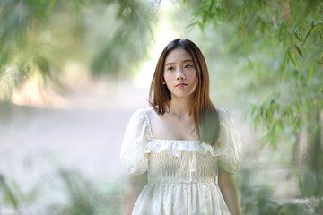 Naklejka premium Beautiful young woman with white dress on garden background