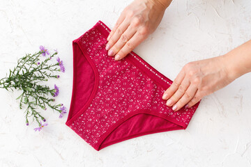 Women's hands with beautiful panties on white background.