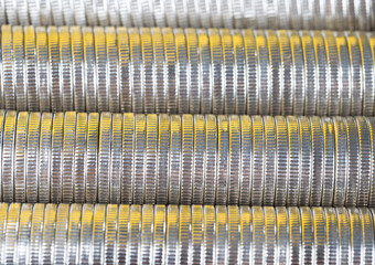 many round metal coins of silver color illuminated in yellow
