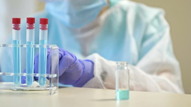 Lab technician in protective clothing drops a bottle of some substance. Errors in work.
