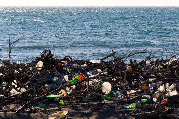 Garbage on the sandy beach, plastic and metal pollution, global warming