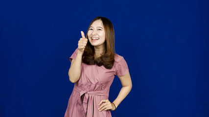 Fototapeta premium beautiful asian woman ok gesture isolated blue background