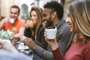 Gathering of multiracial students at cafe. Group of friends enjoying breakfast and cappuccino..