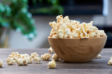 A large wooden bowl with popcorn