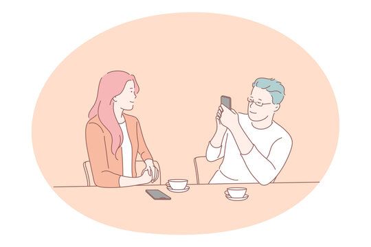 Smartphone, online communication, photo concept. Young man cartoon character making photo of his girlfriend on smartphone during drinking tea at home vector illustration 