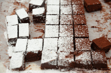 Delicious homemade raw chocolates cut into square shapes sprinkled with powdered sugar. Valentines Day celebration.