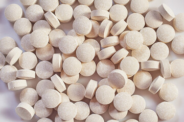 lots of white pills on a red background. viramins, close-up, macro