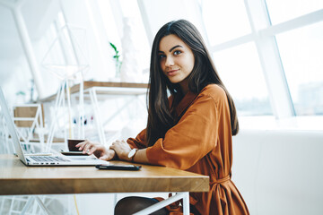 Smiling woman using laptop while working