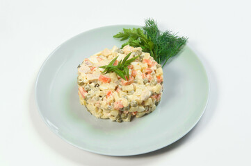 Russian traditional holiday Olivier salad served with spring onion scallions, fresh dill, parsley Dish of boiled vegetables. Christmas New Year cold dish served on plate. Object isolated on background