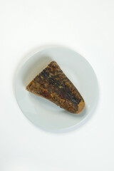 Stuffed carp fish. Jewish traditional whole gefilte fish cut served on plate isolated on white background. Minced fish fillet with vegetables in fish skin backed in oven. Dish isolated on white 

