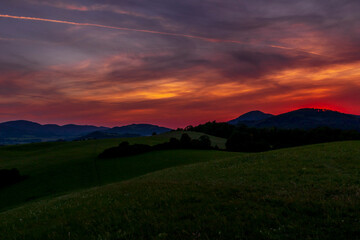 Beskydy mountains Kozlovice landscape with lots of hills and mountains on the horizon and colorful sunset with lots of clouds in the sky.