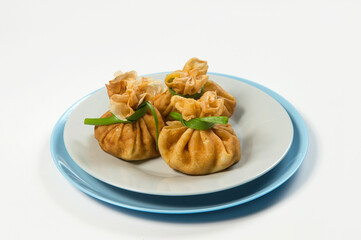 Side view of Holiday Russian starter dish blini. Traditional crepes appetizer with fresh spring onion scallions. Delicious new year Christmas dish. Isolated thin pancakes served on blue, gray plates
