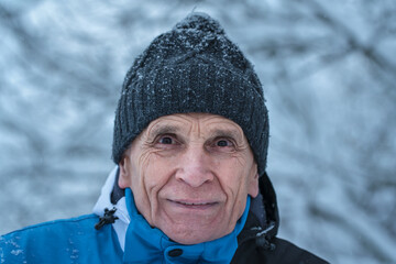 Fototapeta na wymiar Wrinkled face of senior man wearing knitted headwear in winter season