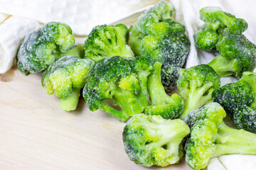 Fresh green frozen broccoli on light background.
