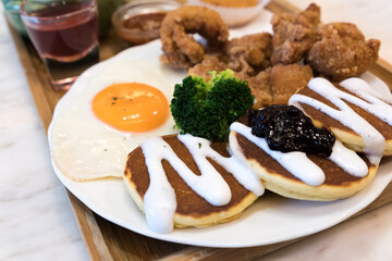 Classic USA breakfast. fried chicken, pancakes waffles, fried eggs.