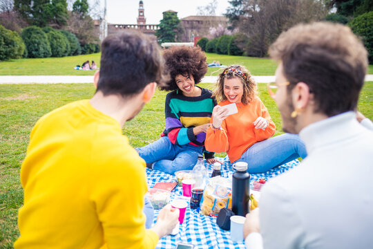 Four friends multiethnic doing pic nic using smartphone