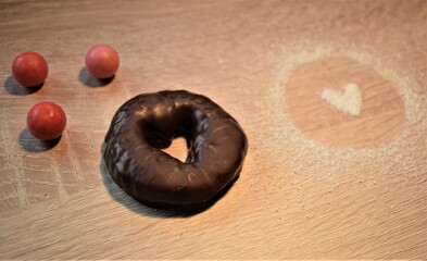 Macro de galleta de chocolate en forma de corazón con decoración de azúcar y bolas rojas