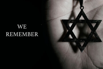 star of david in a pendant and text we remember
