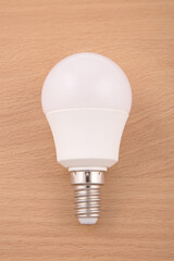 White electric light bulb on a brown background.