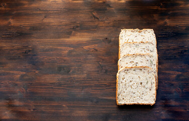 Cereal bread slices on old dark wood background. Image with copy space