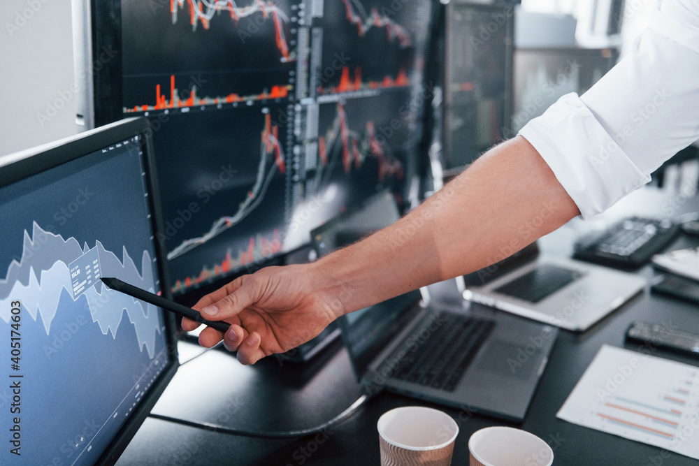 Poster close up view of man's hand that points at part of stock graph on display