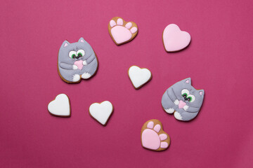 Valentine cookies in form of cats on red colored paper background