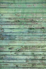 Old wooden fence with green paint background texture.
