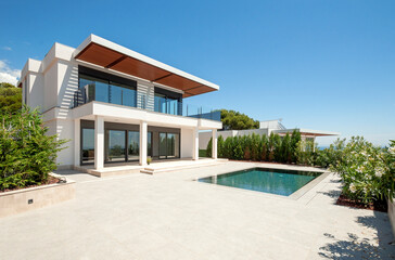 The modern facade of a luxury villa with a large swimming pool. Luxury MODERN property. - obrazy, fototapety, plakaty