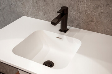 Modern white washbasin with mixer tap in bathroom.