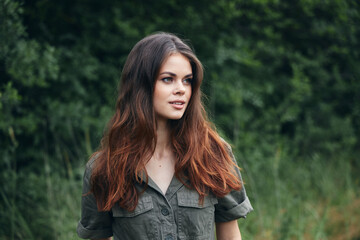 Fototapeta premium woman in the forest Looks aside long hair green suit fresh air nature 