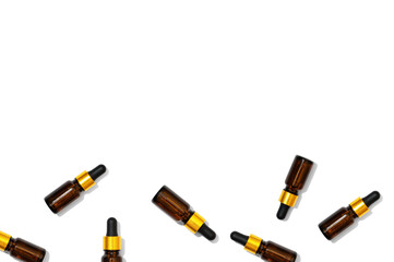 Glass bottles from dark glass texture on a white background. A cosmetic product with essential oils and hyaluronic acid. Beauty product for moisturizing and nourishing the skin. Copy space, frame