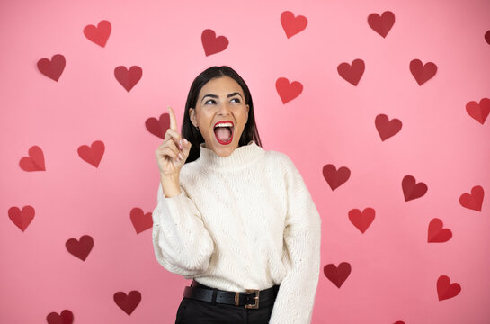 Young Beautiful Woman Over Pink Background With Harts Smiling And Thinking With Her Fingers On Her Head That She Has An Idea.