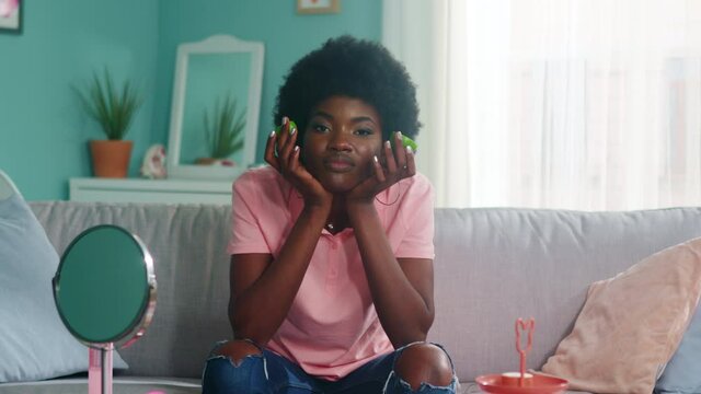 Portrait of young pretty woman, Afro-American, staying home, bored and tired, looking at camera and missing her friends, Foreground, Slow motion.