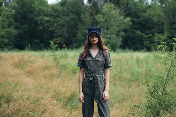 Naklejka na ściany i meble woman in nature in a gray overalls and a cap on her head