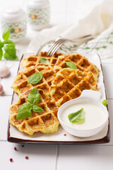 Homemade zucchini waffles with cheese,sause and leaf basil on white background. Concept of keto diet food. Selective focus.