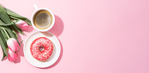 Fototapeta na wymiar March 8, International Women's Day. number eight, consisting of a cup of coffee and a donut with a pink filling, next to pink tulips on a pink background. space for text