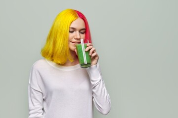 Young teenager girl with green vegetable smoothie drink, healthy vegan diet, copy space