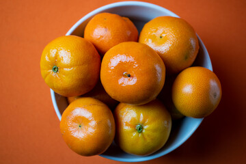 clementines in a bowl with orange background