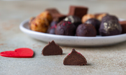 Variety of sweet homemade chocolate candies and truffles, light concrete background.