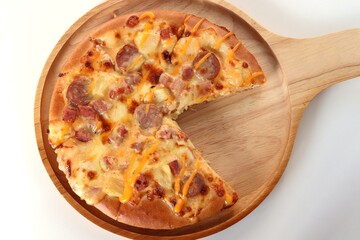 top view of pizza in wooden tray on white table